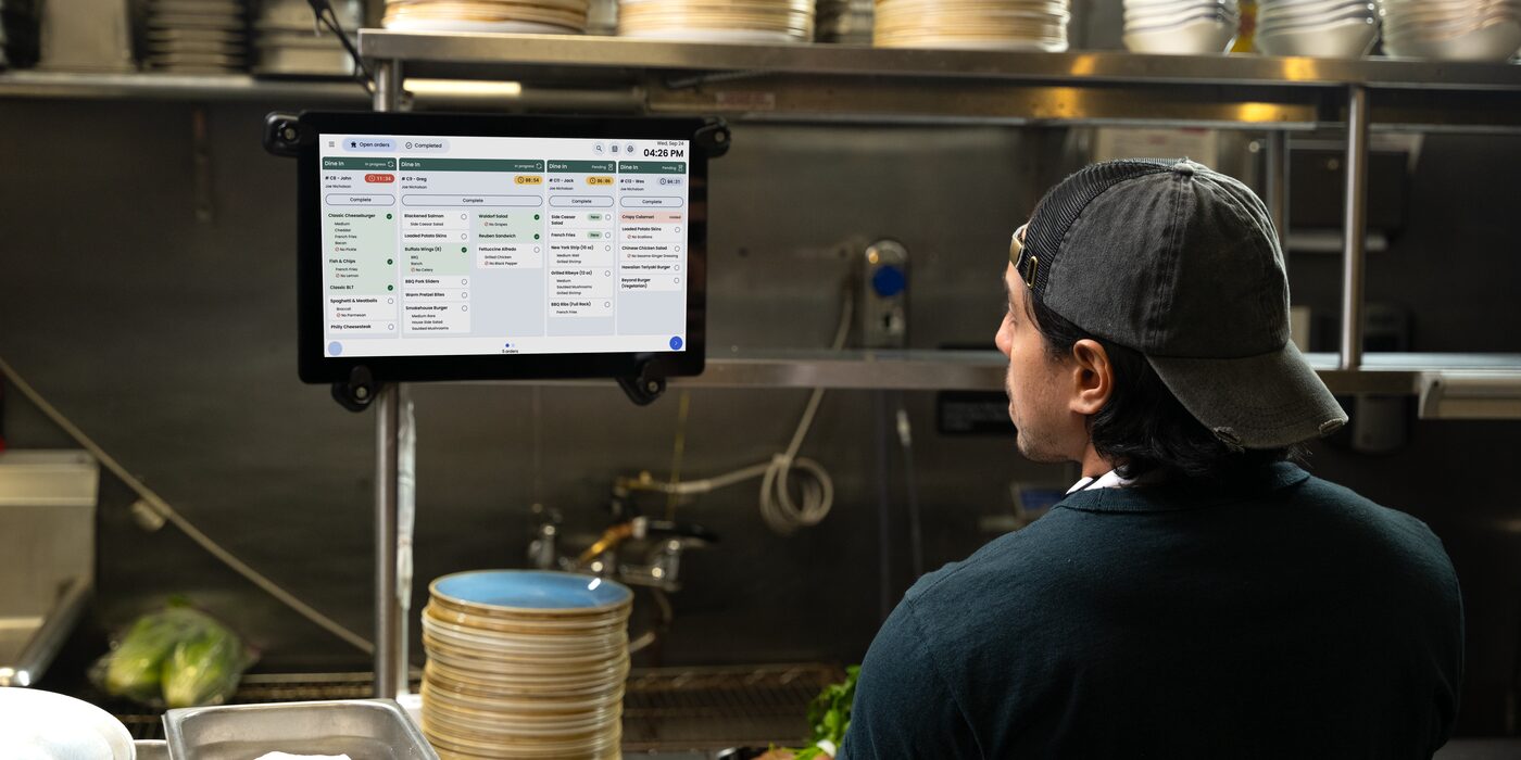 A cook reading orders on a kitchen display