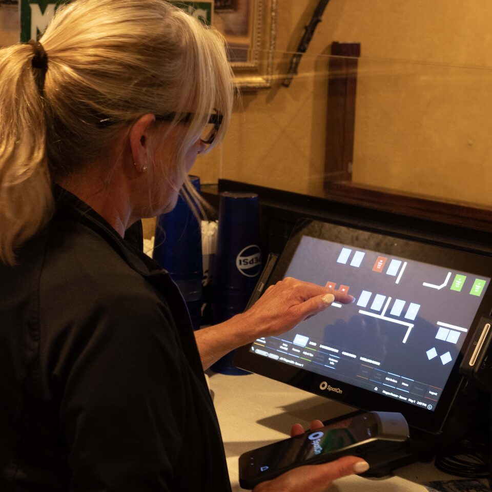 A server at a SpotOn counter station in a restaurant